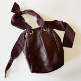 Reversible mini tie bag in oxblood leather. Made to order in NYC.